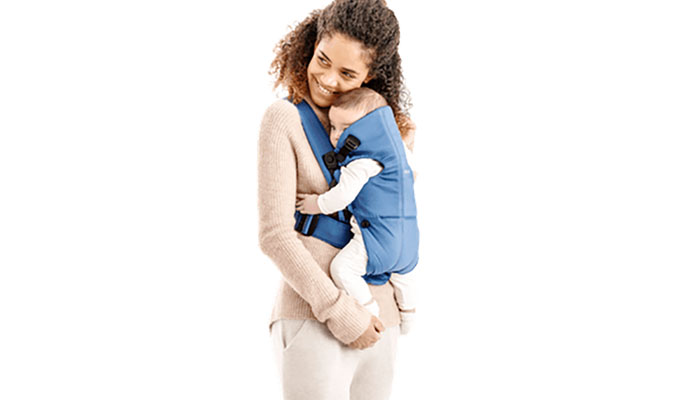 Une maman qui porte son bébé dans le Porte-bébé Mini de Babybjörn