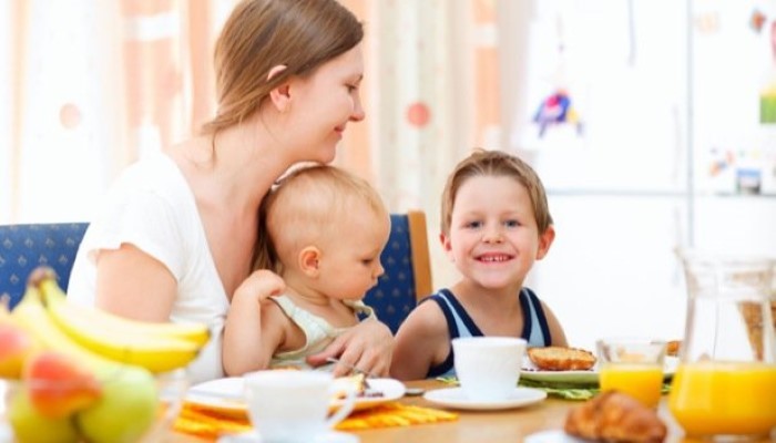 Maman, petit garçon et bébé qui prennent le petit dejeuner