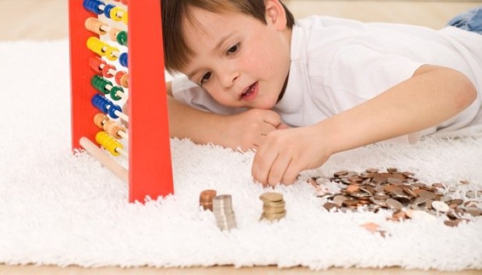 Petit garçon qui joue avec des pièces d'euros Petit garçon qui joue avec des pièces d'euros
