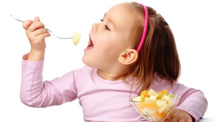 Petite fille qui mange une salade de fruits Petite fille qui mange une salade de fruits