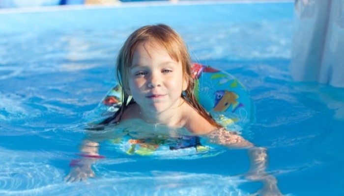 Petit garçon qui nage avec un flotteur Petit garçon qui nage avec un flotteur