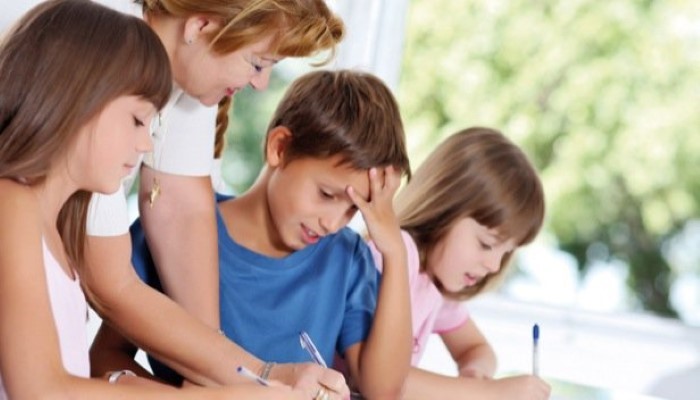Maman qui aide ses enfants à faire les devoirs Maman qui aide ses enfants à faire les devoirs