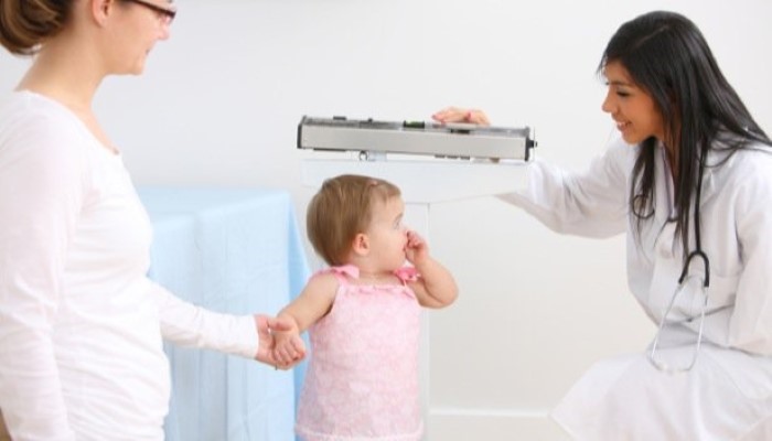 Docteur qui mesure et pèse un enfant