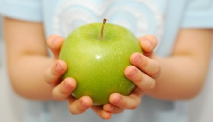 Enfant tenant une pomme dans ses mains