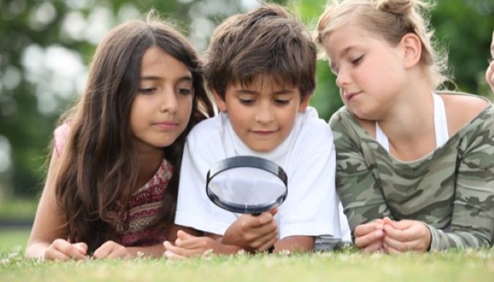 Enfant qui joue avec une loupe