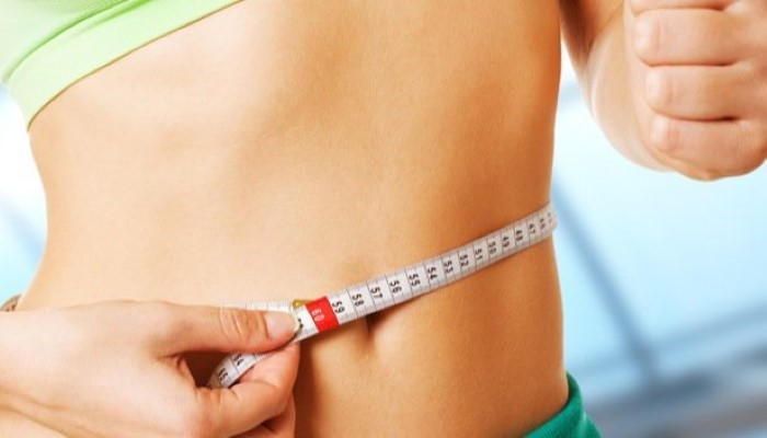 Femme qui mesure son tour de taille Femme qui mesure son tour de taille