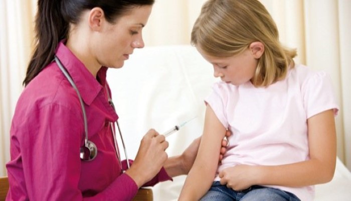 Médecin qui fait une piqure à une petite fille