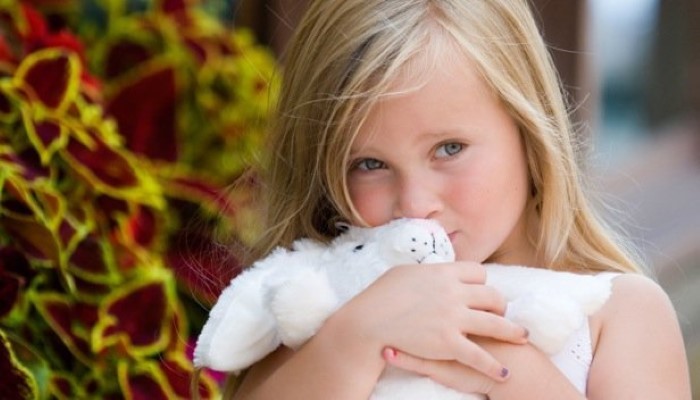 Petite fille qui fait un câlin à son doudou