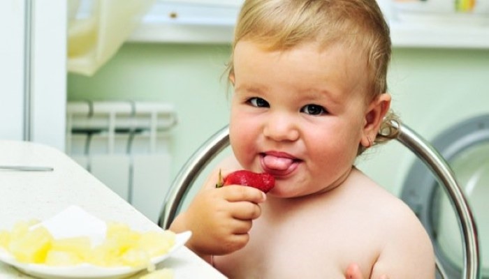 Enfant qui mange une fraise