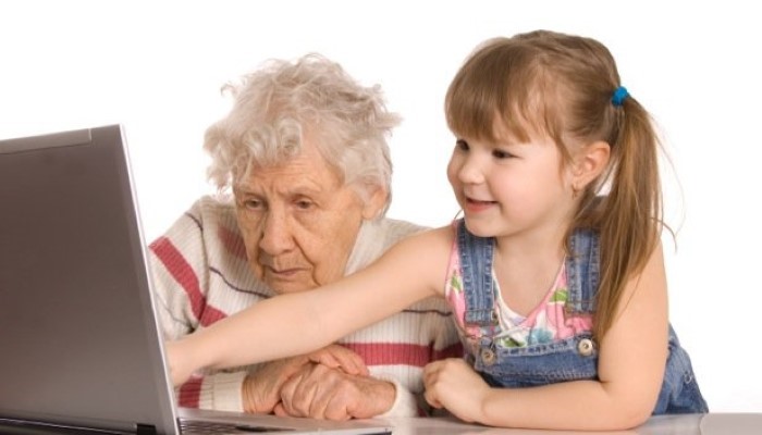 Petite file et sa grand-mère devant un ordinateur Petite file et sa grand-mère devant un ordinateur