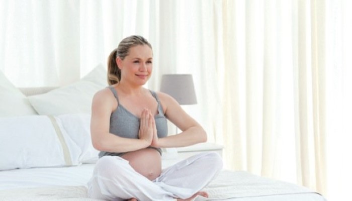 Femme enceinte qui fait du yoga