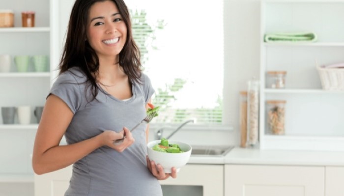 Femme enceinte qui mange une salade