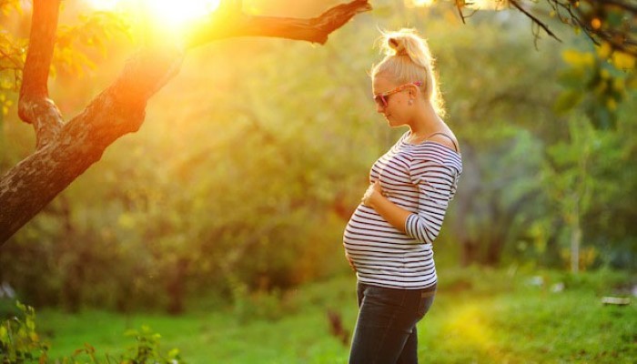 Femme enceinte qui se promène au soleil Femme enceinte qui se promène au soleil