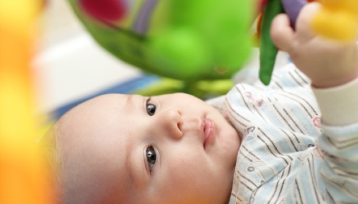 Bébé qui joue sur son tapis d'éveil Bébé qui joue sur son tapis d'éveil