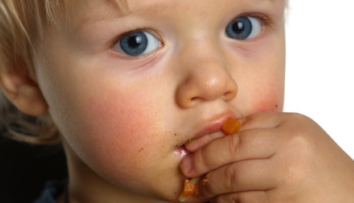 Petit enfant qui mange avec ses mains