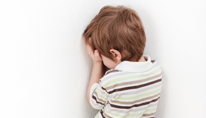 Petit enfant qui se cache dans un coin