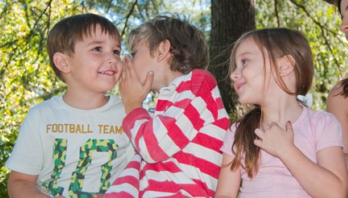 Enfants qui se racontent des messes basses Enfants qui se racontent des messes basses