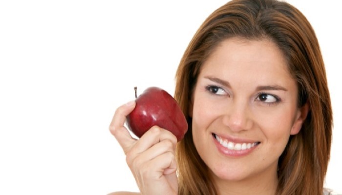 Femme qui tient une pomme dans sa main