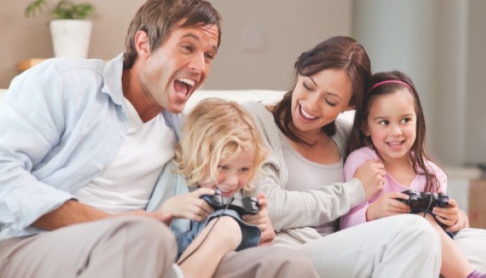 Des parents et leurs enfants jouent à la console vidéo Des parents et leurs enfants jouent à la console vidéo