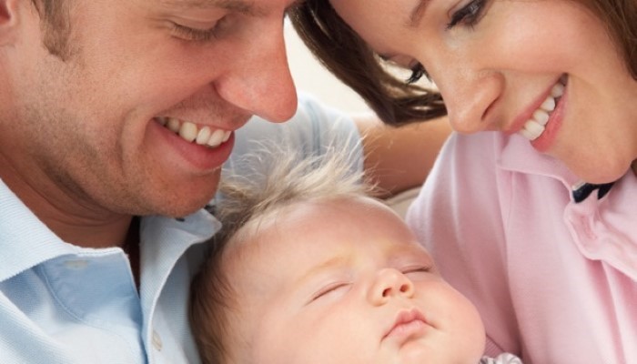 Papa et maman qui entourent leur bébé Papa et maman qui entourent leur bébé