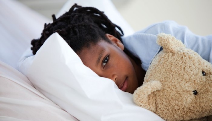 Petite fille au lit avec son doudou