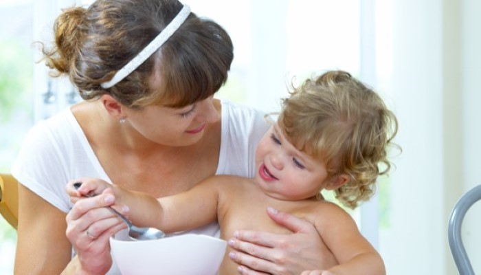 Maman qui donne à manger à son enfant Maman qui donne à manger à son enfant