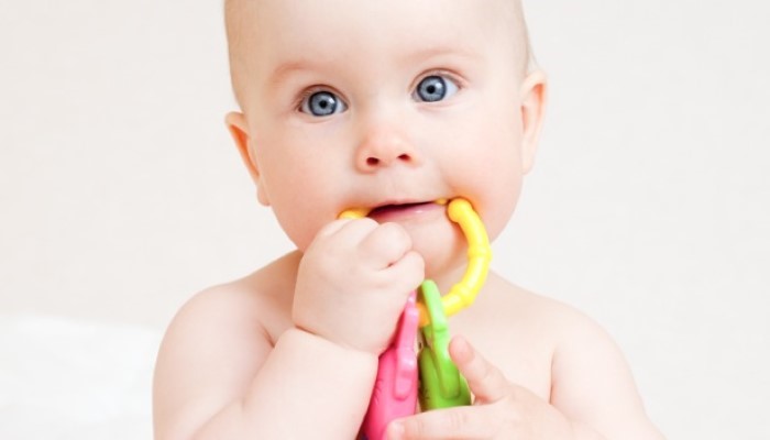 Bébé qui met un jouet dans la bouche
