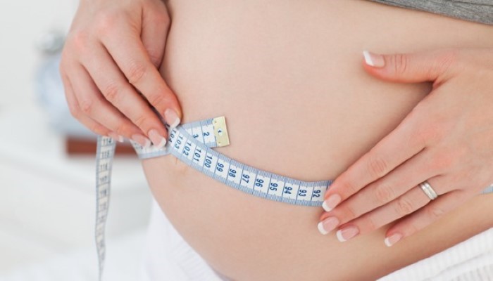 Femme enceinte mesurant la taille de son ventre