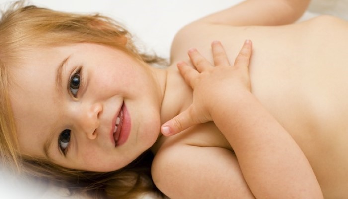 Petite fille qui se tient la poitrine Petite fille qui se tient la poitrine