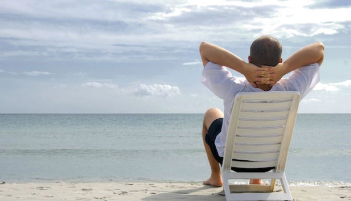 Homme qui se détend sur un transat à la plage Homme qui se détend sur un transat à la plage