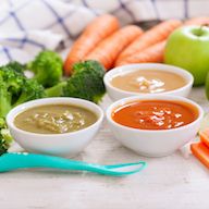 Bébé dans son siège haute qui mange Bébé dans son siège haute qui mange