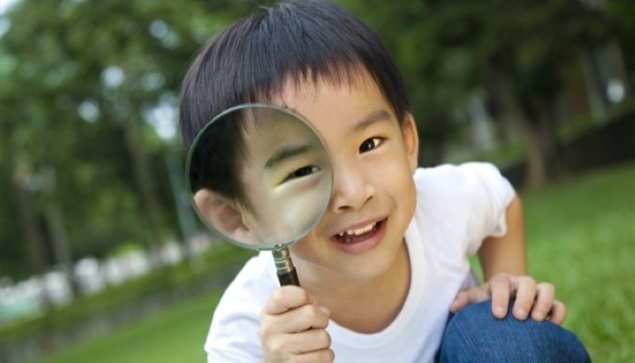 Enfant qui joue avec une loupe
