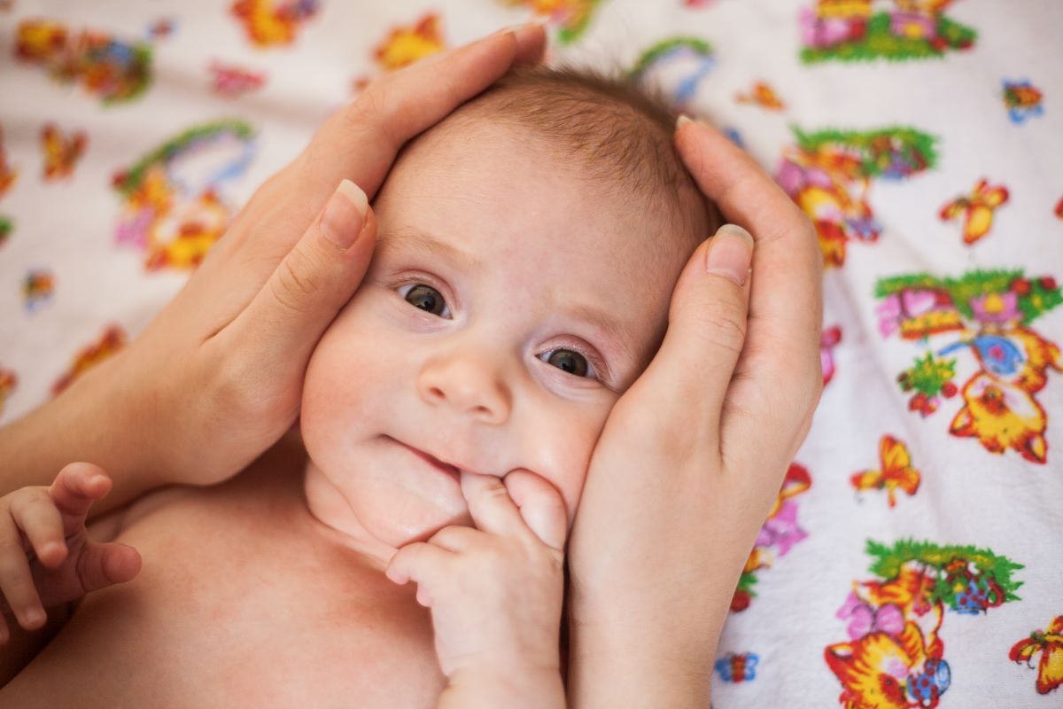 Maman qui masse le visage de son bébé
