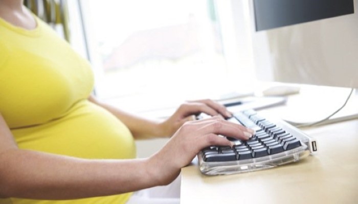 Femme enceinte devant un ordinateur Femme enceinte devant un ordinateur