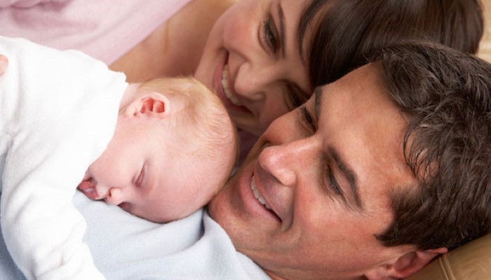 Papa et maman qui regardent bébé dormir Papa et maman qui regardent bébé dormir