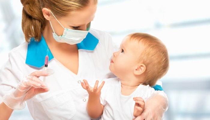 Infirmière qui va faire une piqure à un bébé Infirmière qui va faire une piqure à un bébé