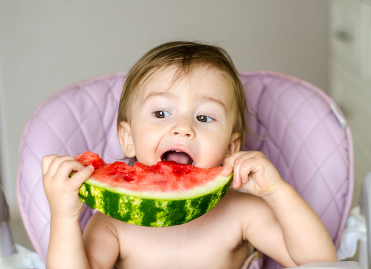 Bébé qui mange une compote de pomme Bébé qui mange une compote de pomme