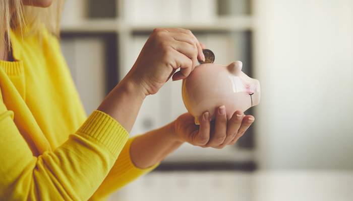 Femme qui met une pièce dans une tirelire Femme qui met une pièce dans une tirelire