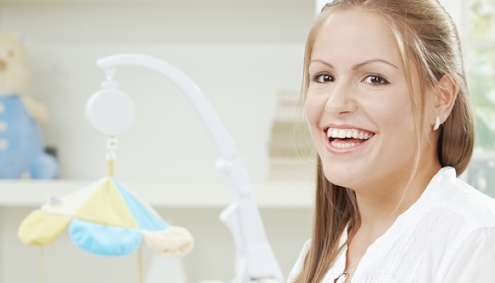 Maman qui pose le mobile au-dessus du lit de son bébé Maman qui pose le mobile au-dessus du lit de son bébé