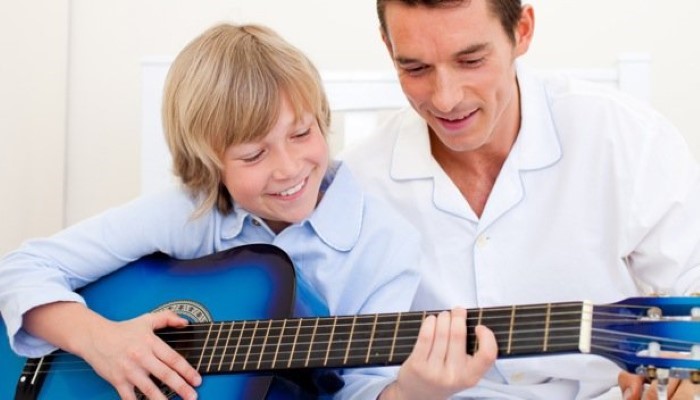 Garçon qui apprend la guitare avec son père Garçon qui apprend la guitare avec son père