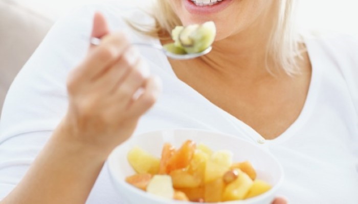 Femme mangeant une salade de fruits