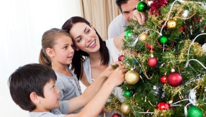 Famille qui décore un sapin de noël