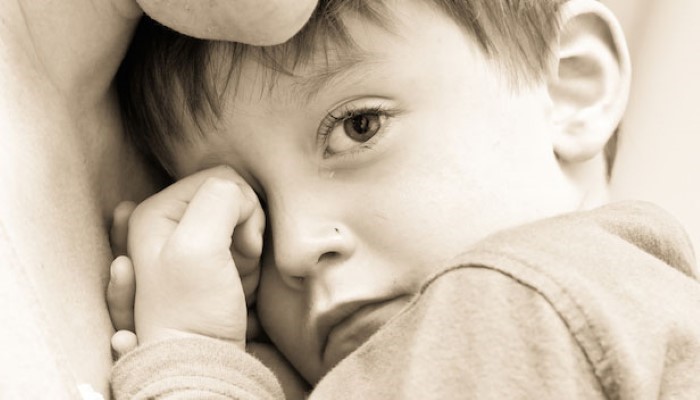 Enfant triste aux bras de sa maman Enfant triste aux bras de sa maman