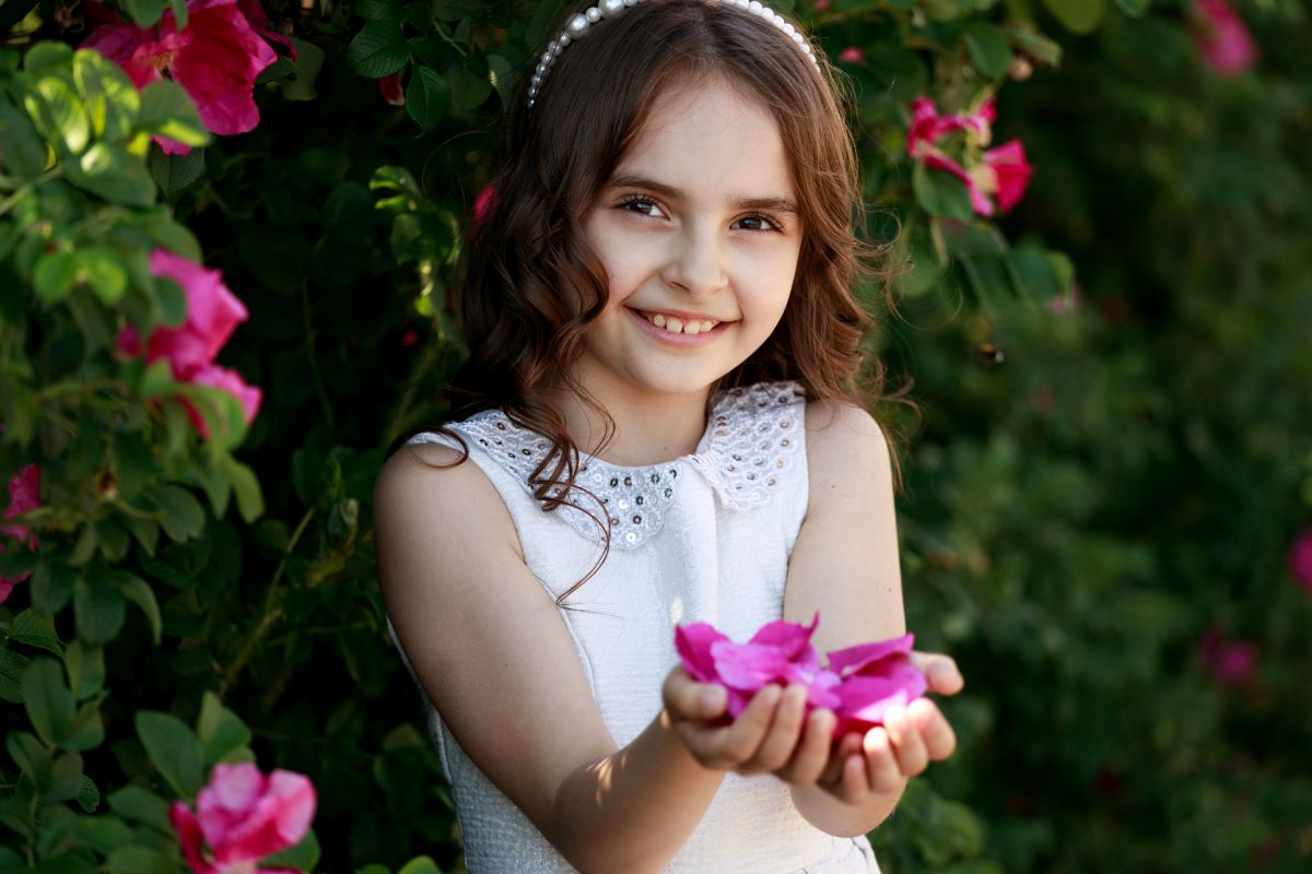 Petite fille qui sent une grande fleur