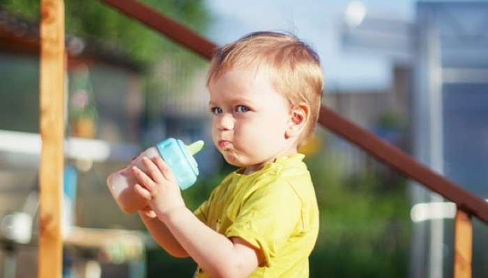 Bébé qui prend son biberon en vacances Bébé qui prend son biberon en vacances