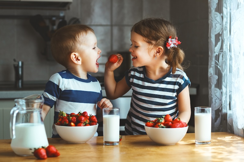 Enfant qui mange un yaourt pour le goûter