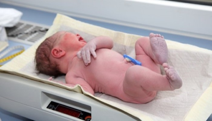 Bébé nouveau-né sur une balance Bébé nouveau-né sur une balance