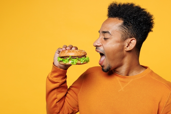 Homme qui mange un hamburger