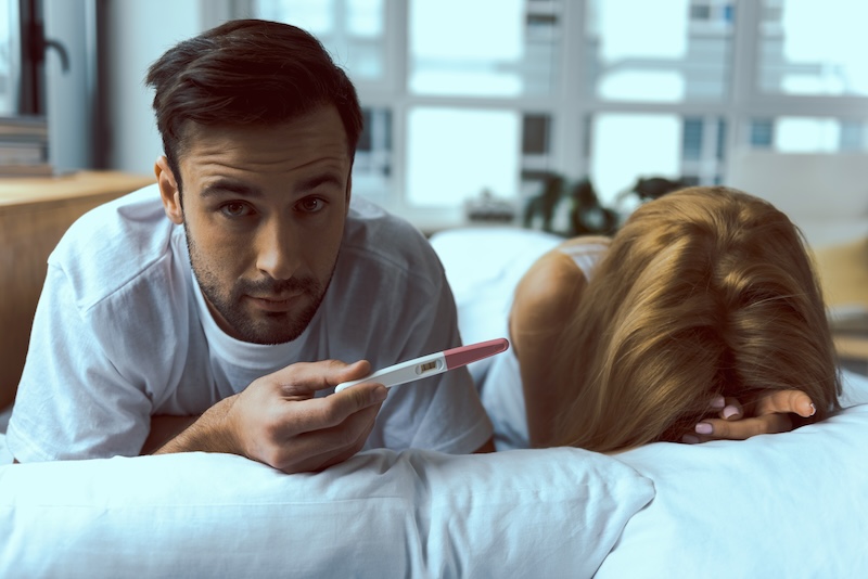 Homme qui fait un test de grossesse positif