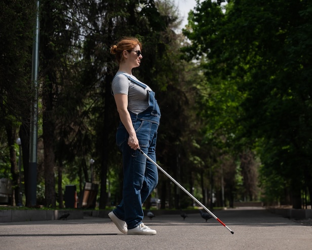 Femme enceinte aveugle qui se promène dans la rue